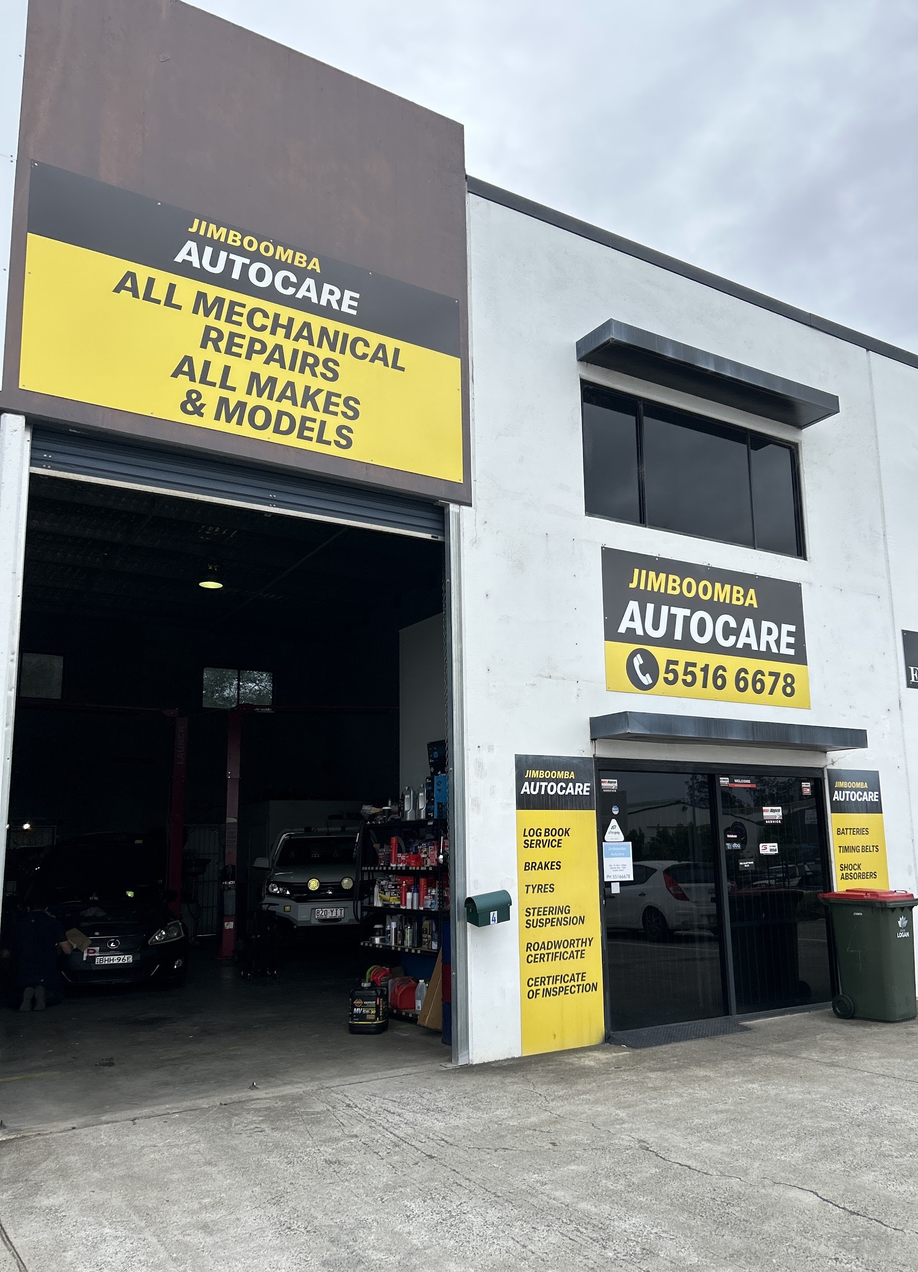 The Jimboomba Autocare shopfront on Paul Court, roller door open with cars on the hoist inside